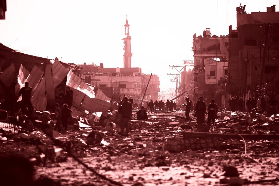 A palestinian woman sitting and holding a baby in a refuggee camp in Khan Younis